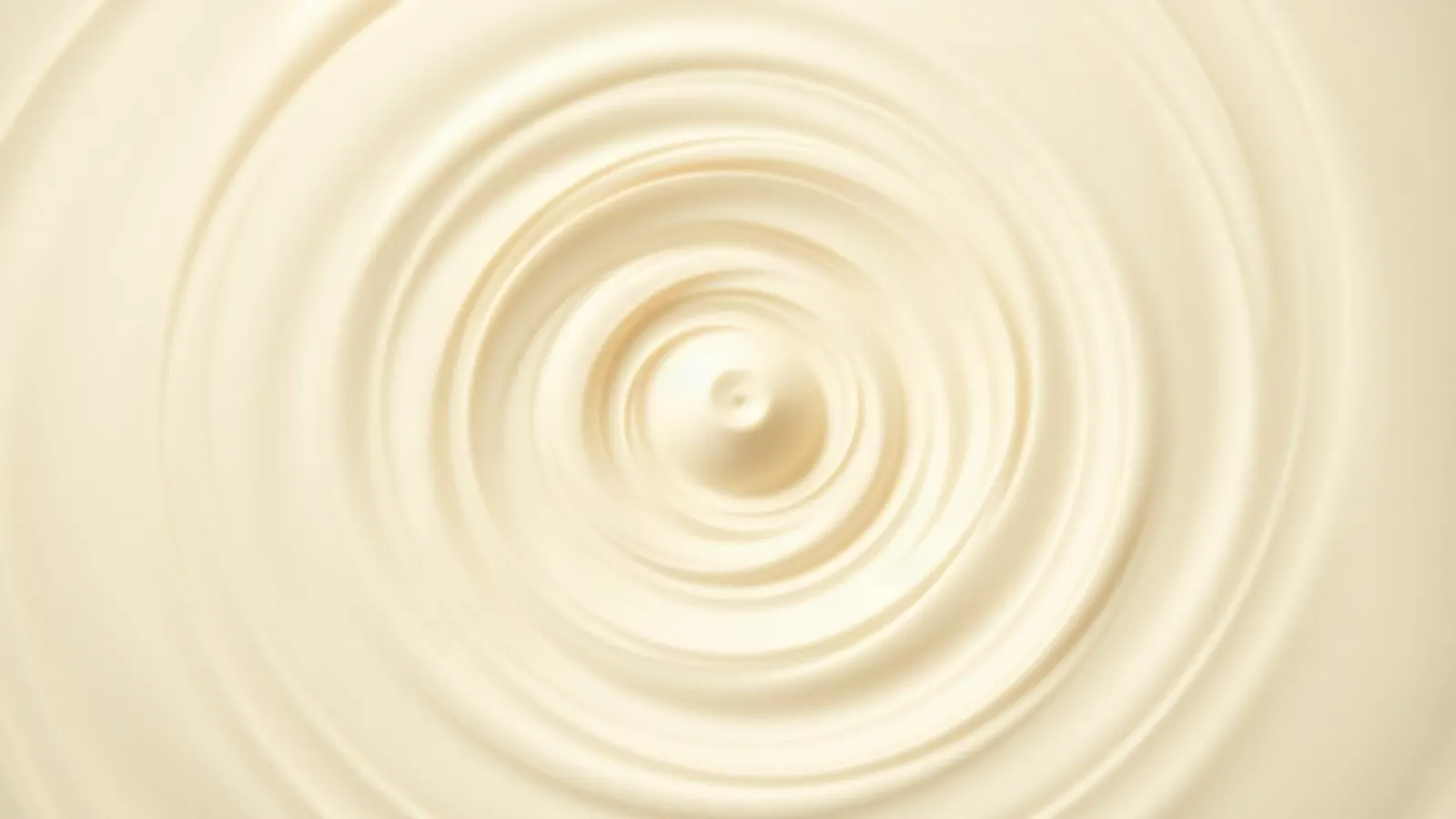 Slow vortex in pale cream coloured liquid